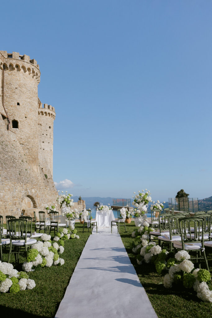 Outdoor wedding ceremony aisle at Castello di Rocca Cilento with white hydrangeas, photographed by Australian destination wedding photographer Evelina Katarzynski