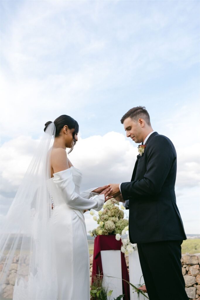 Bride and groom exchanging rings during an intimate destination wedding ceremony at Masseria Amastuola in Puglia, Italy.