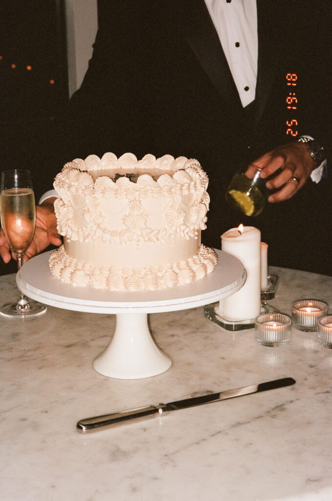 35mm film photo of a ruffled white wedding cake being served at a Manly Pavilion reception