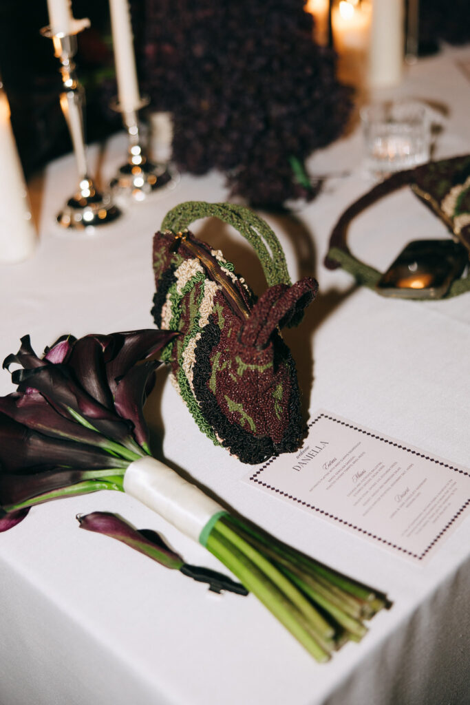 Wedding table detail with black calla lily bouquet, embroidered evening bag and personalised menu card at Whites Vallet Estate in McLaren Vale.