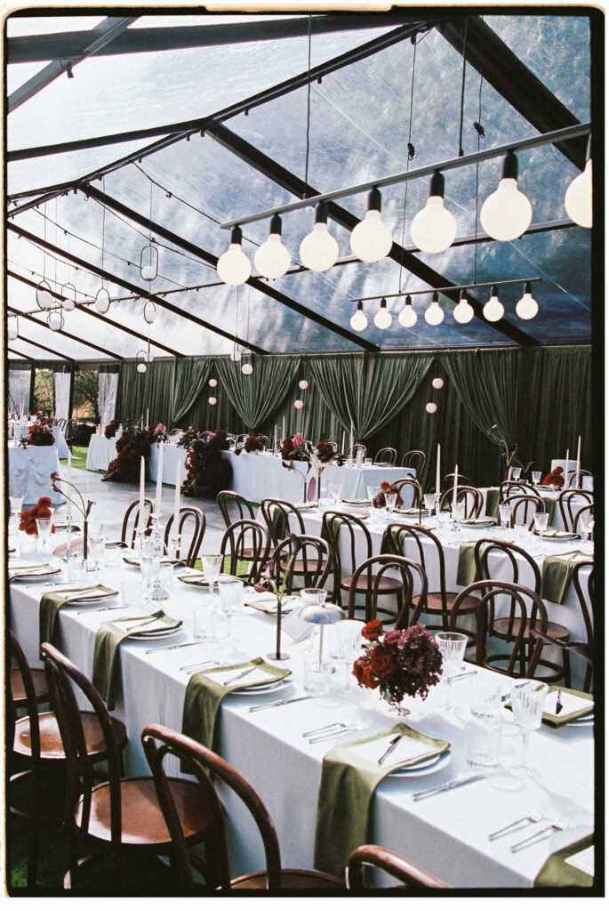 Marquee reception interior with pendant lights and long dining tables at Whites Valley Estate.