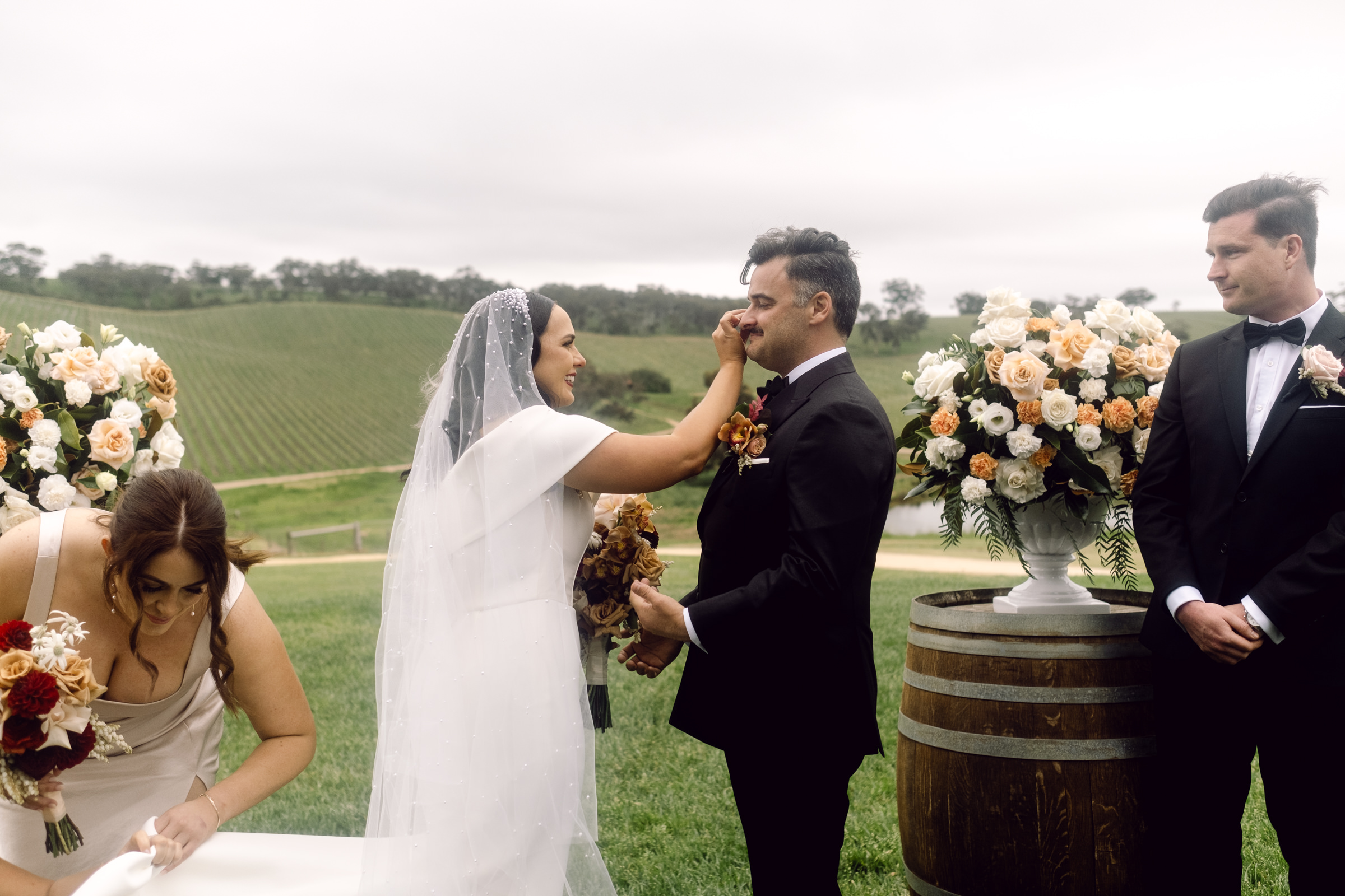 a bride wipes a tear off her grooms face after walking down the isle at Longview Vineyard in the Adelaide Hills