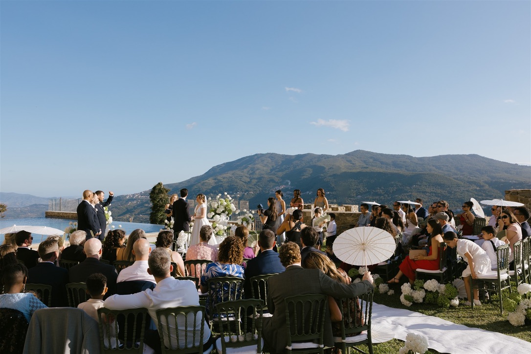 Outdoor wedding ceremony at Castello di Rocca Cilento with guests overlooking the mountains in Southern Italy, photographed by Evelina Katarzynski.