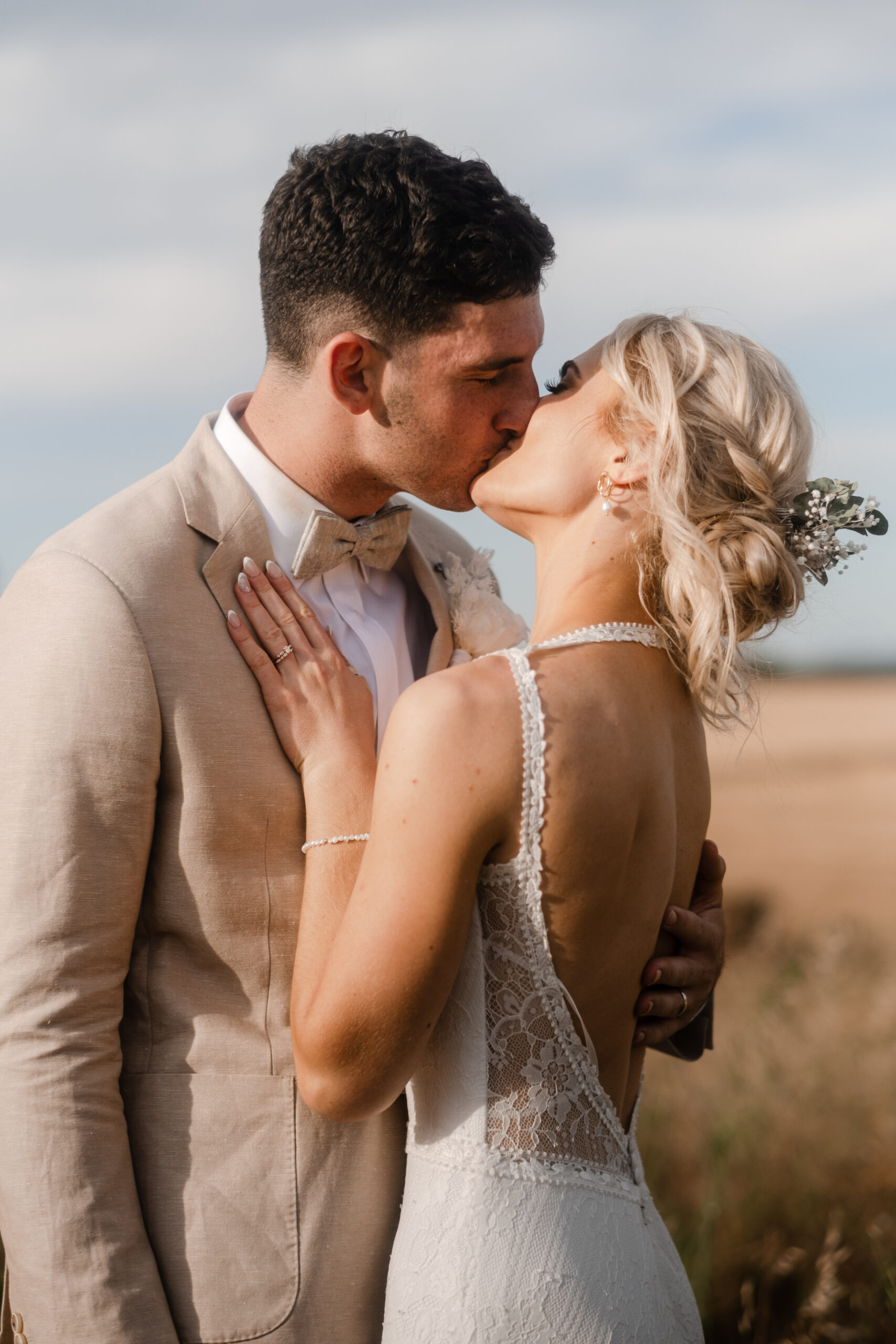 a bride and groom share a kiss with the open fields of Strathalbyn in the backgroun