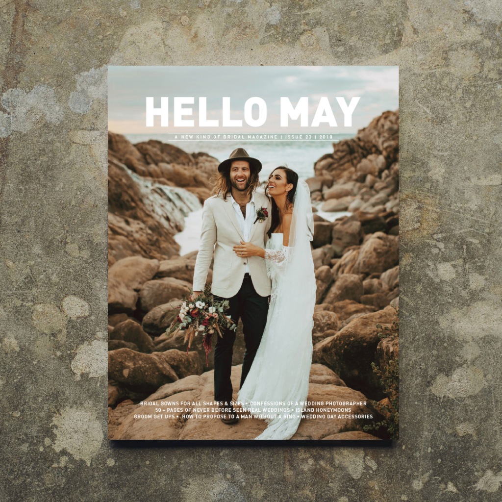 the cover of hello may magazine and wedding blog, a couple embrace enveloped by a rocky coastline