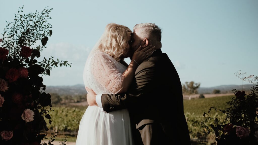 a bride and groom share their first kiss at The Lane Vineyard in the Adelaide Hills