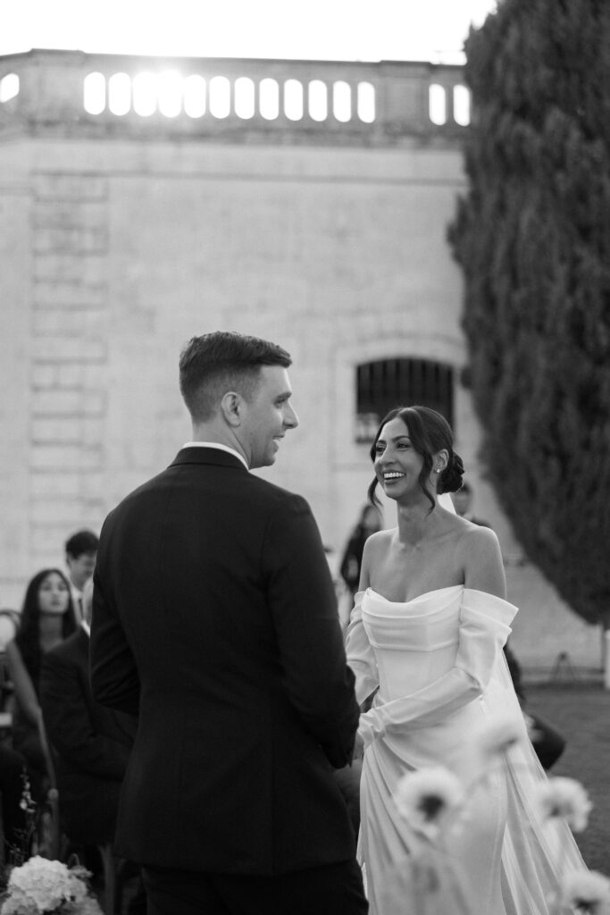 Bride and groom exchanging smiles during their wedding ceremony at Masseria Amastuola