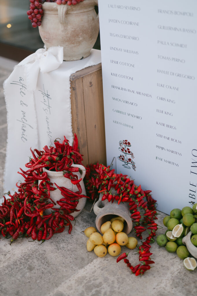 Still life of chilli, citrus, and stationery details at a Masseria Amastuola wedding
