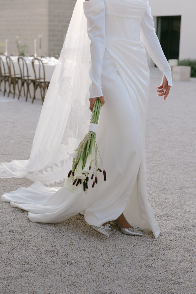 Bride walking through the courtyard in a Kyha Studios wedding dress at Masseria Amastuola