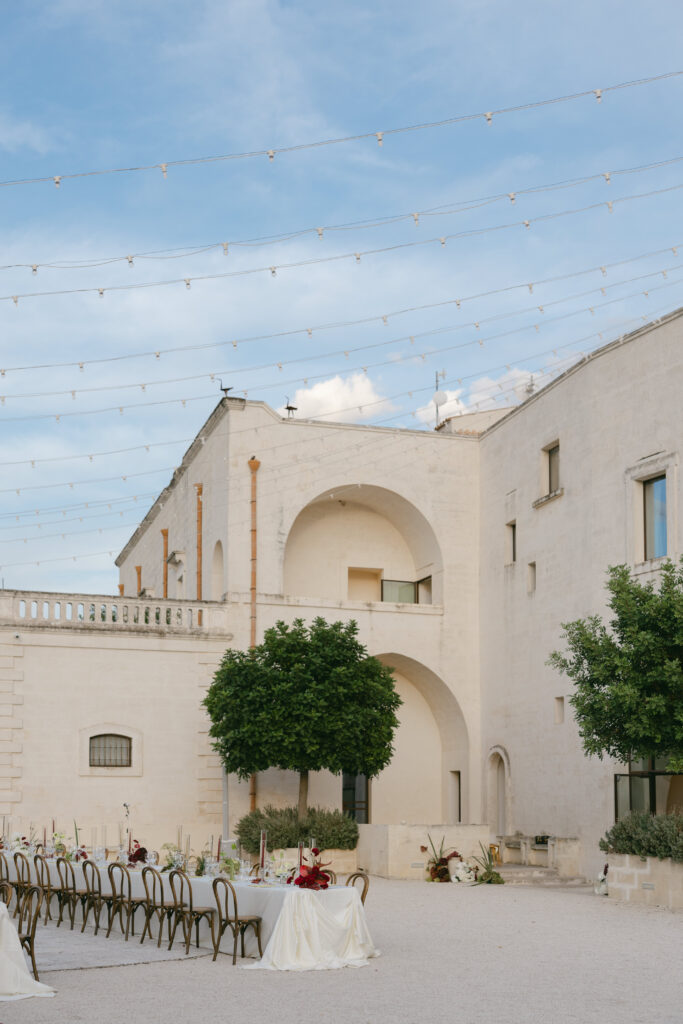 Courtyard setup at Masseria Amastuola with long tables beneath string lights