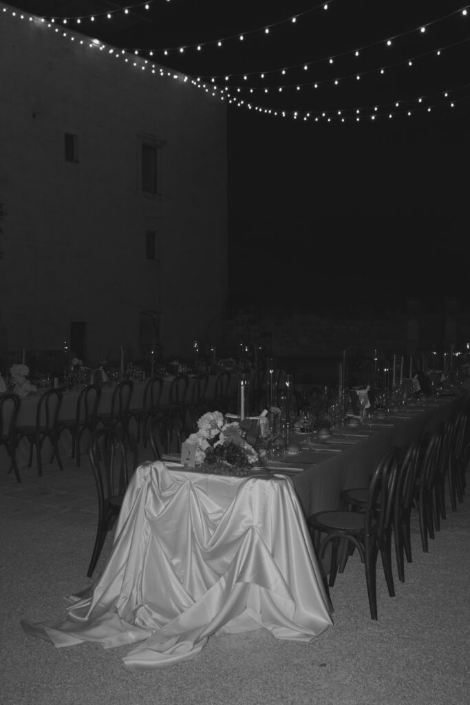 Black and white view of the candlelit courtyard dinner at Masseria Amastuola