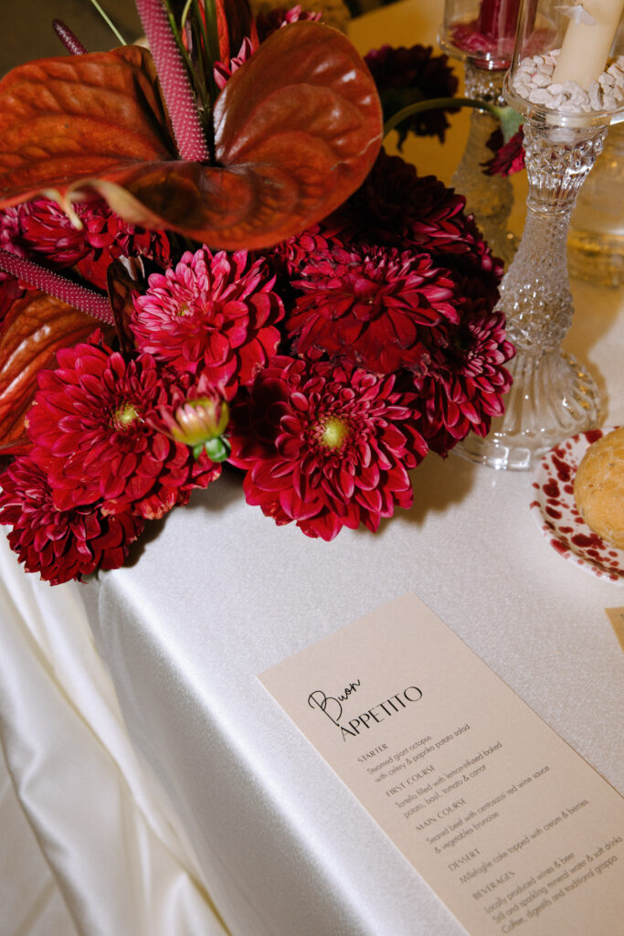 Wedding stationery and plum-toned floral arrangement at a Masseria Amastuola wedding