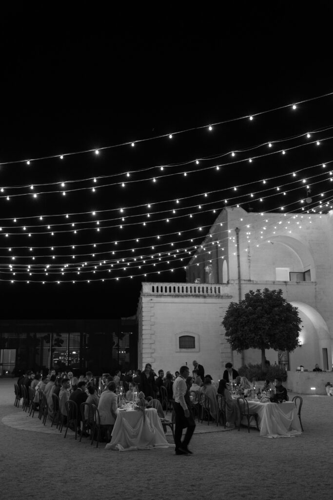 Evening courtyard reception at Masseria Amastuola under string lights