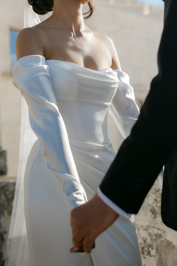 Close-up of the bride holding hands with the groom during their wedding in Puglia