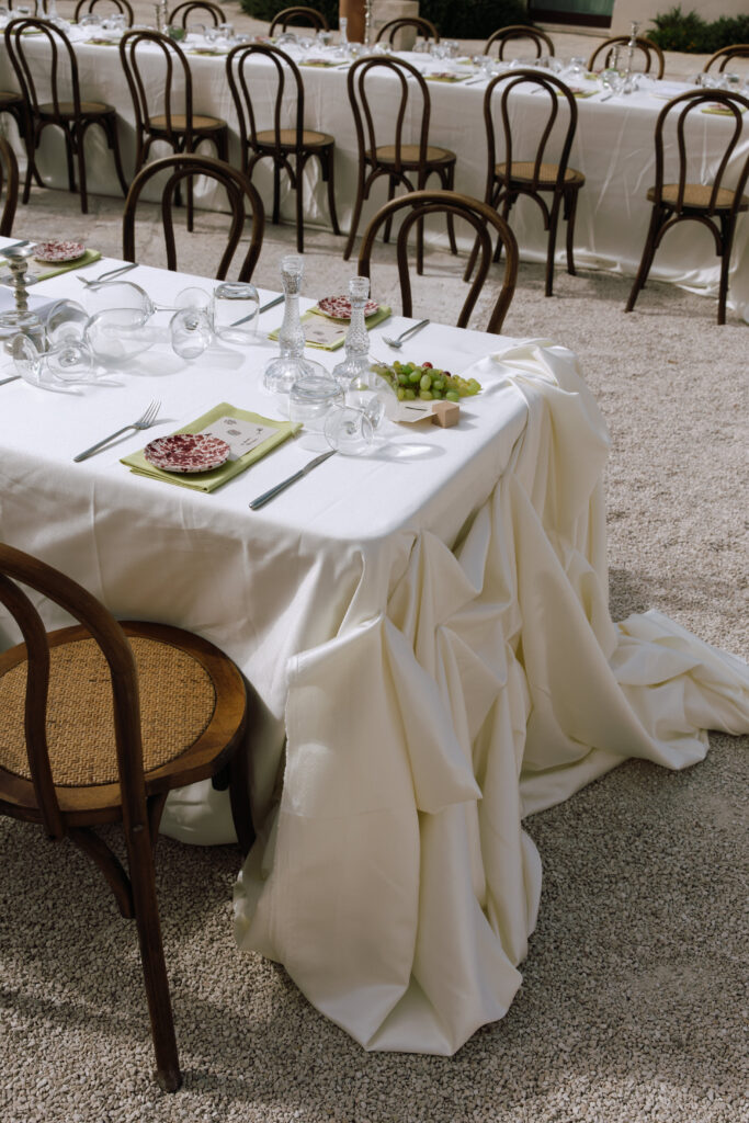 Table setting with draped linens and bentwood chairs at Masseria Amastuola in Puglia