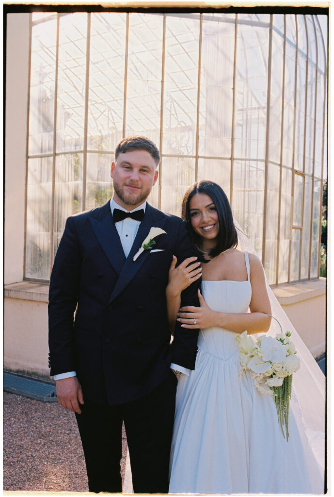 35mm film wedding photography, bride and groom portrait in front of greenhouse, Evelina Katarzyński