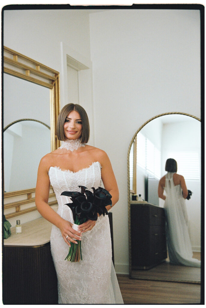 35mm film wedding photography, bride in strapless gown holding dark bouquet smiling, Evelina Katarzyński