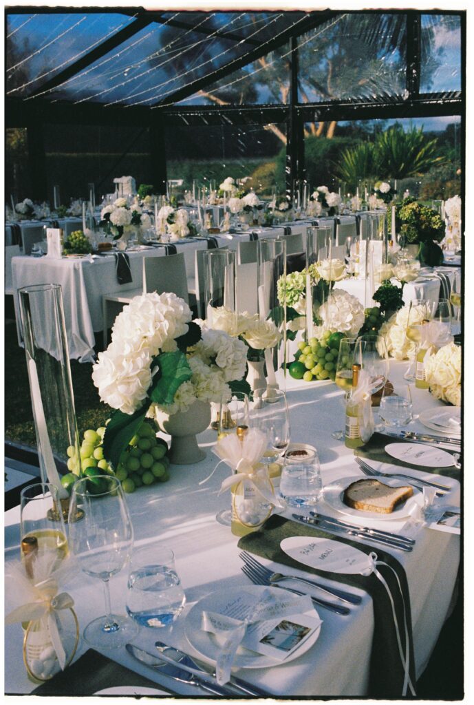 35mm film wedding photography, reception tablescape with white hydrangeas and glassware under glass ceiling, Evelina Katarzyński
