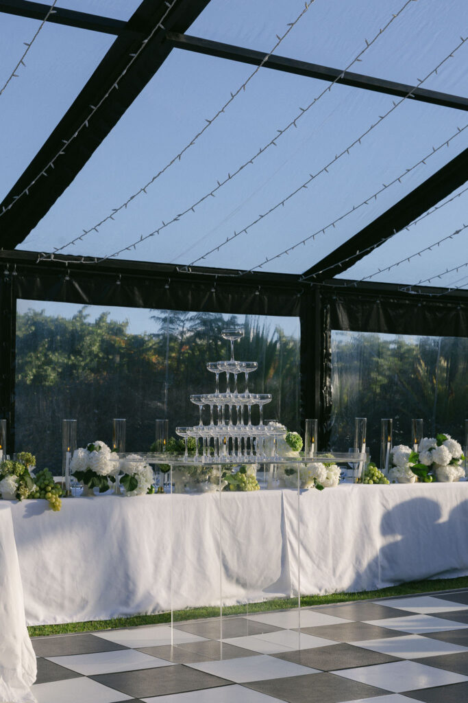 Champagne tower and floral centrepiece inside the Beresford Estate marquee, set over the checkerboard dance floor.