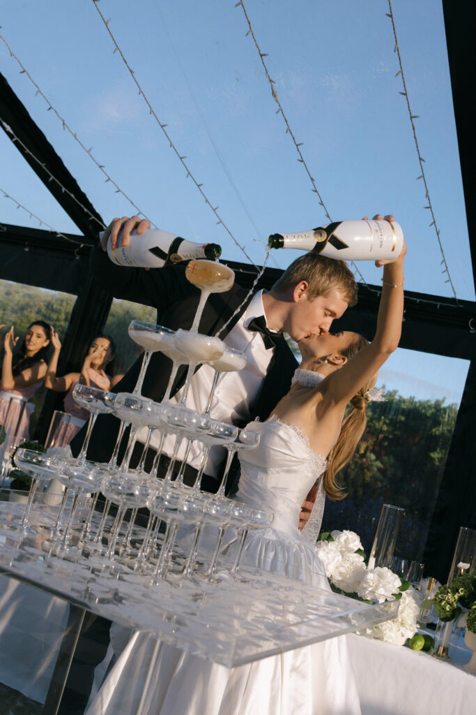 Bride and groom sharing a kiss beside the champagne tower during their Beresford Estate reception.