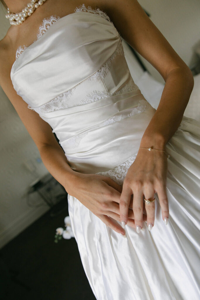 Close-up of the bride's lace wedding gown detail and pearl necklace at Beresford Estate.