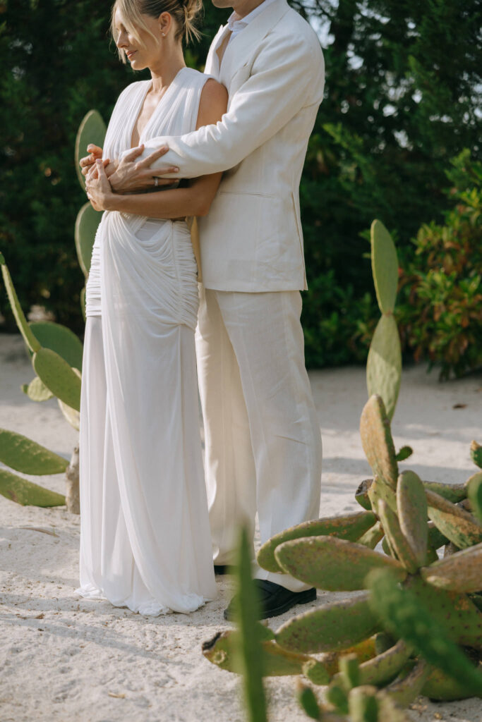 Couple embracing among cactus garden at Quinta da Comporta wedding welcome dinner