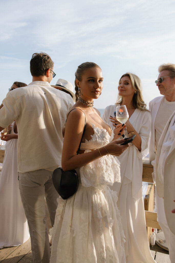 Bride in embellished gown with guests at Portugal wedding welcome dinner