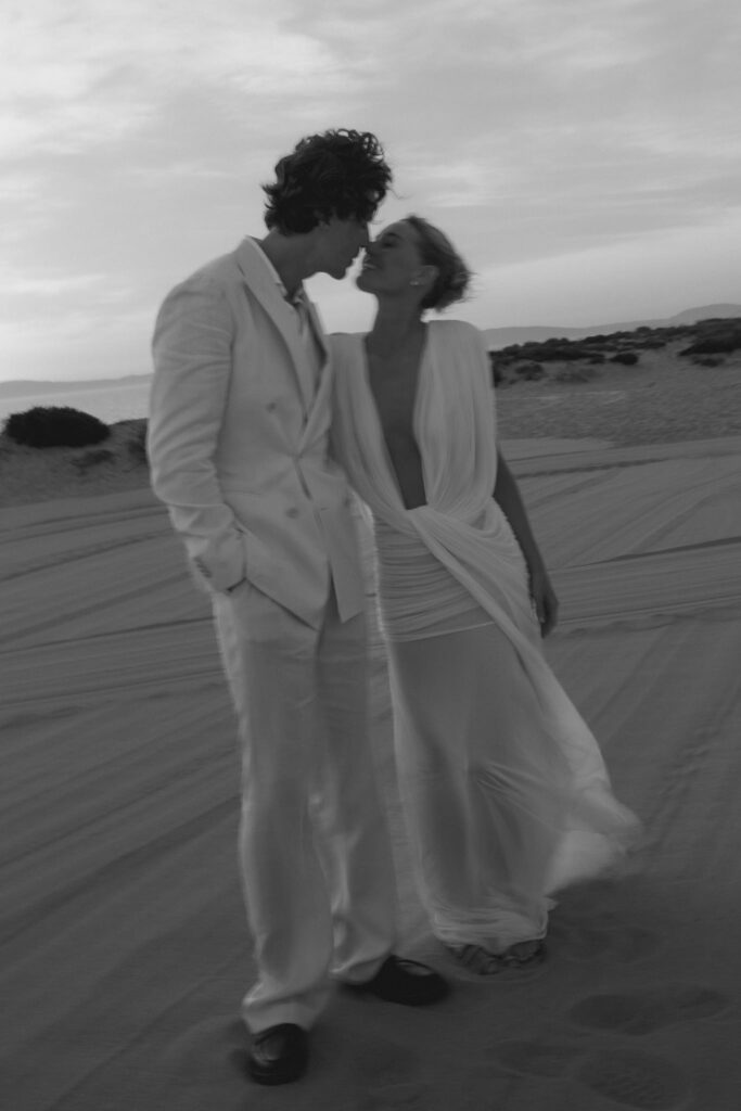 Couple sharing a moment at sunset on the sand dunes at Sublime Beach Club, Comporta, Portugal