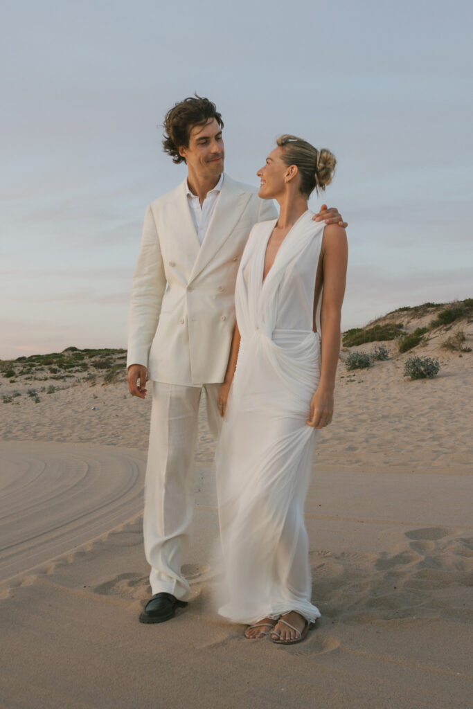 Couple walking together on the sand dunes at Sublime beach club near Comporta, Portugal