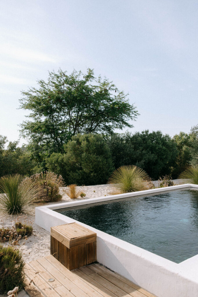 Pool deck and garden at Quinta da Comporta, Portugal, surrounded by native dune scrub