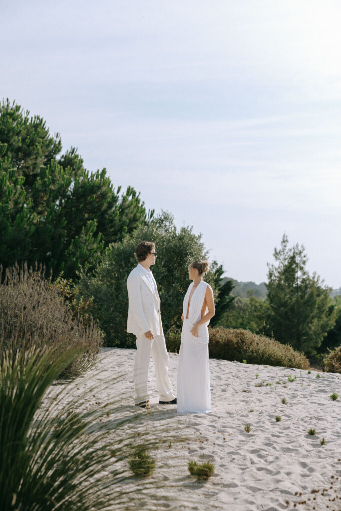 Couple standing together on the sand dunes at a Portugal wedding welcome dinner