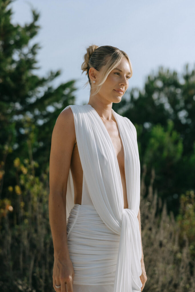 Bride portrait in draped white gown among pine trees in Comporta, Portugal