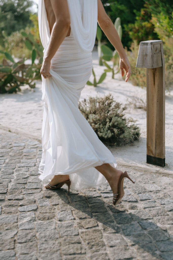 Bride walking cobblestone path in flowing gown at Portugal wedding welcome dinner