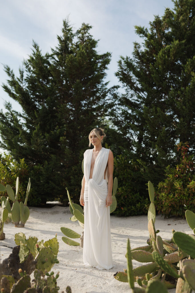 Bride in flowing white gown among cypress and cactus garden at Quinta da Comporta, Portugal
